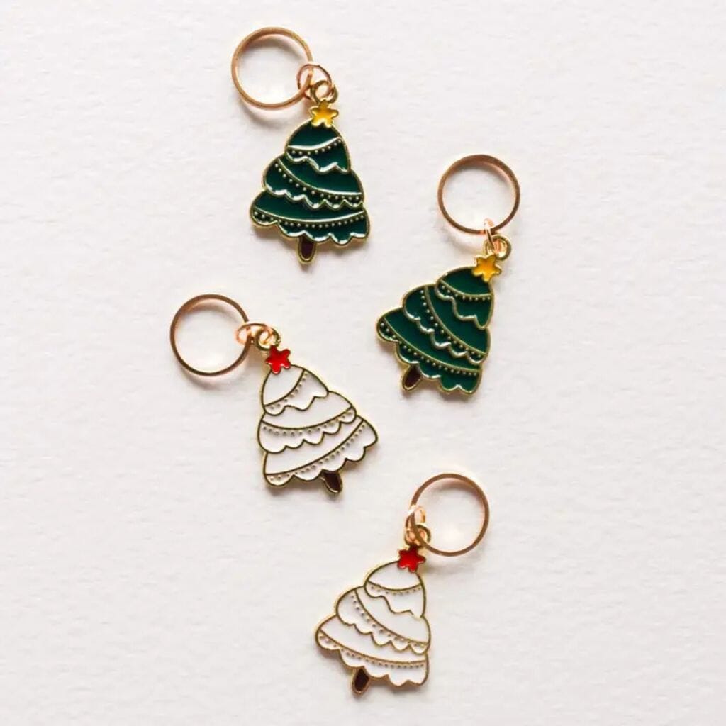Four Christmas tree stitch markers on a white background