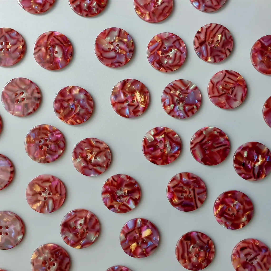 Pattern of red and gold buttons on a white background