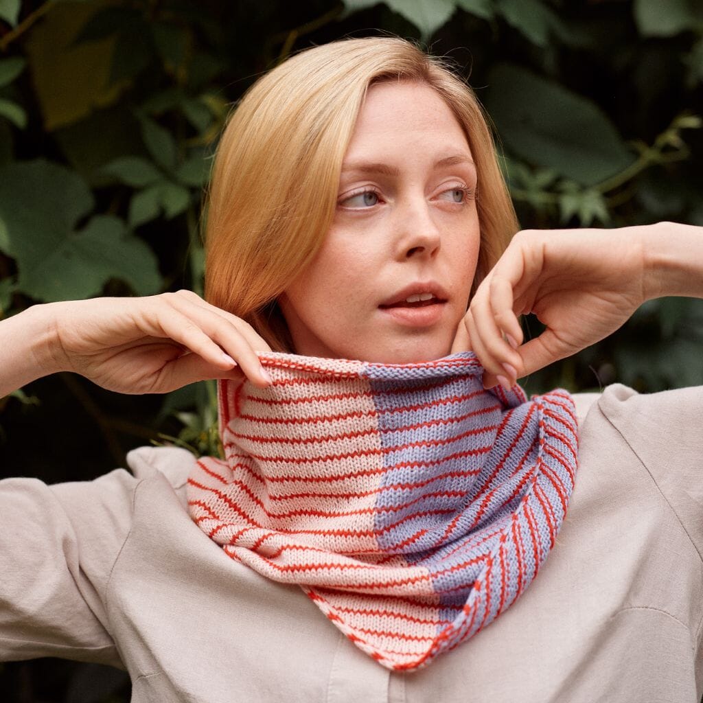 Woman wearing a striped knitted cowl against a natural background