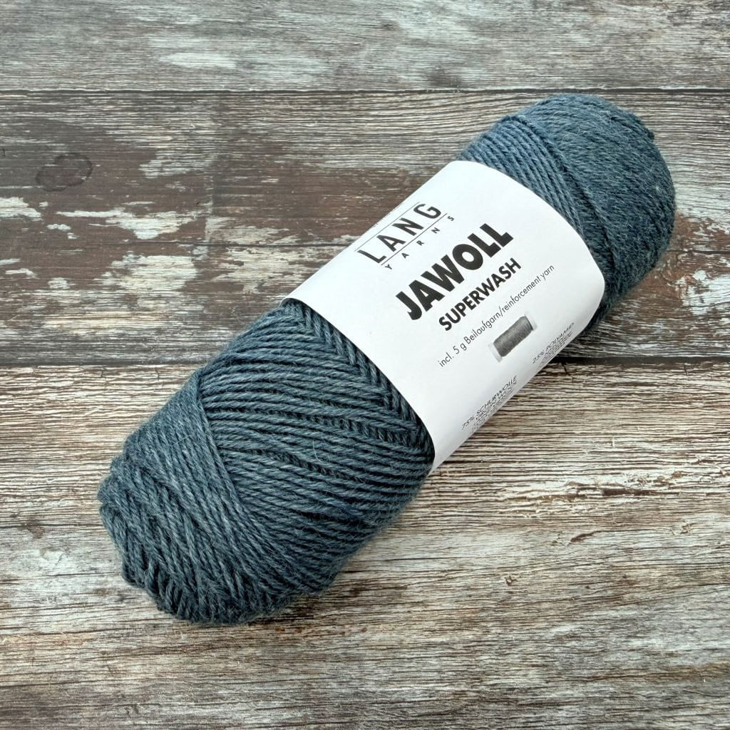Denim Ball of yarn with a label on a wooden surface