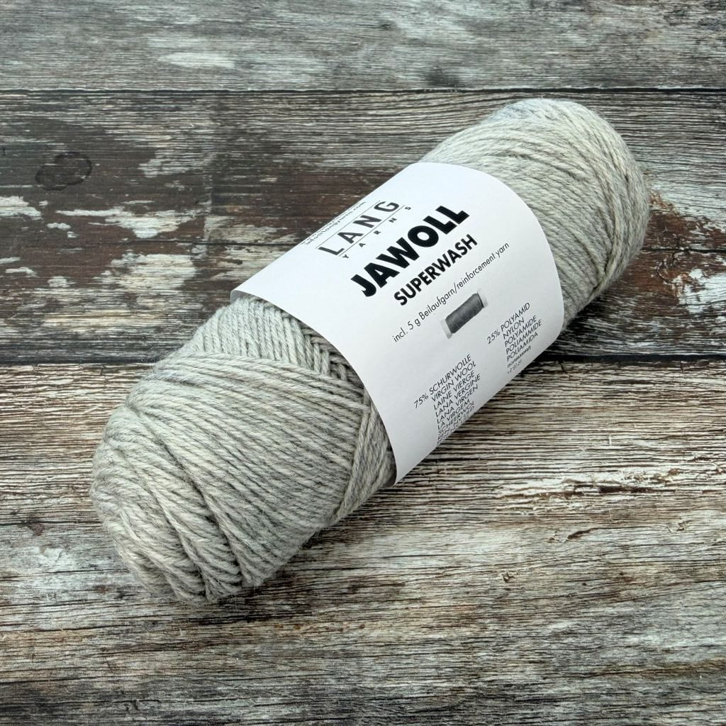 Grey Ball of yarn with a label on a wooden surface
