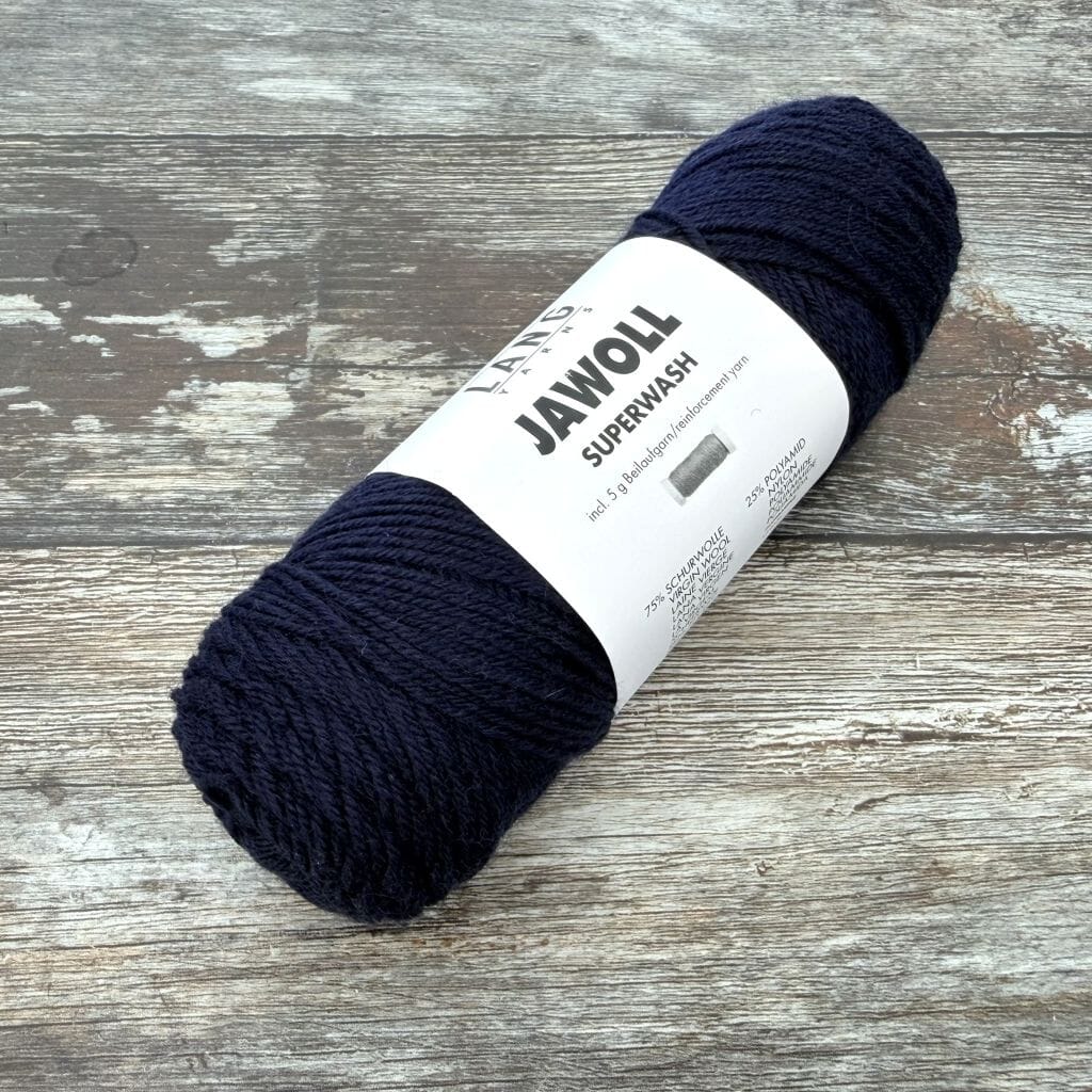 Navy ball of yarn with a label on a wooden surface