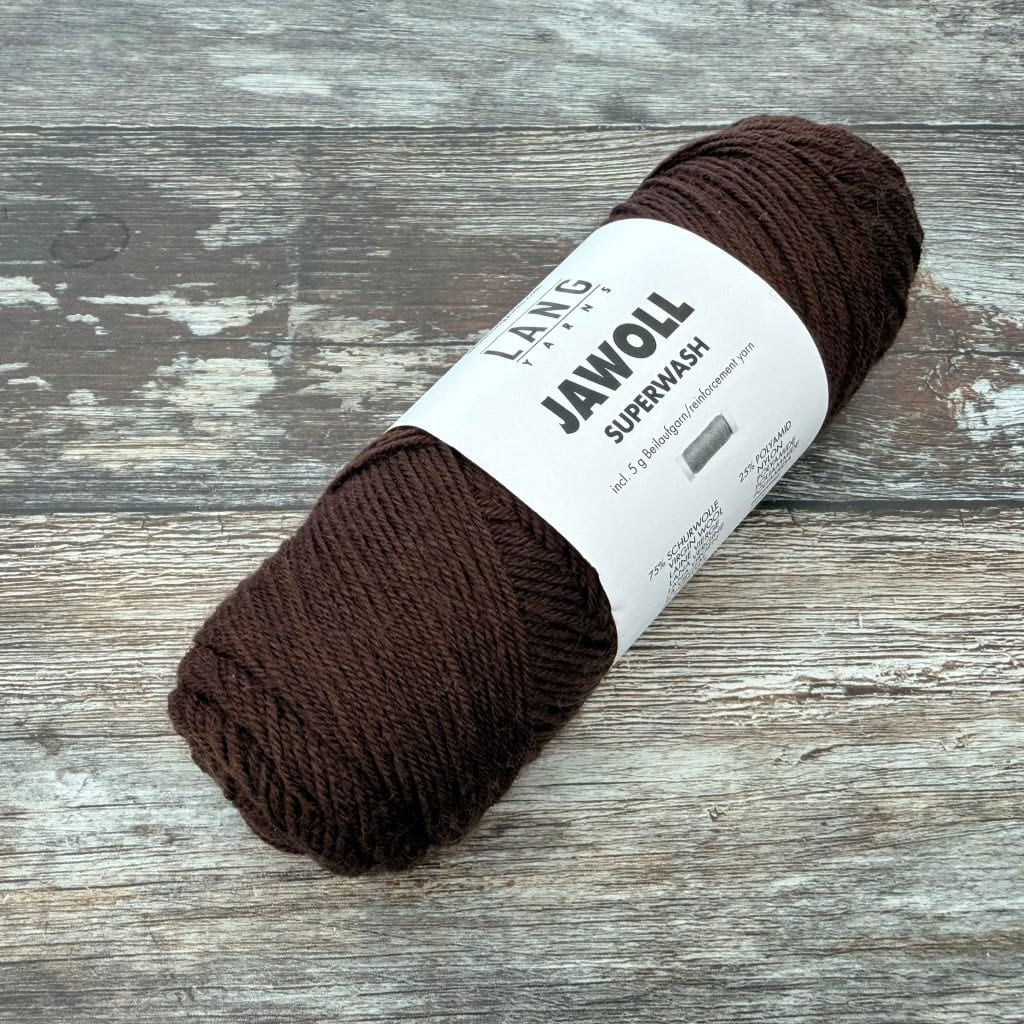 Brown ball  of yarn with a label on a wooden surface