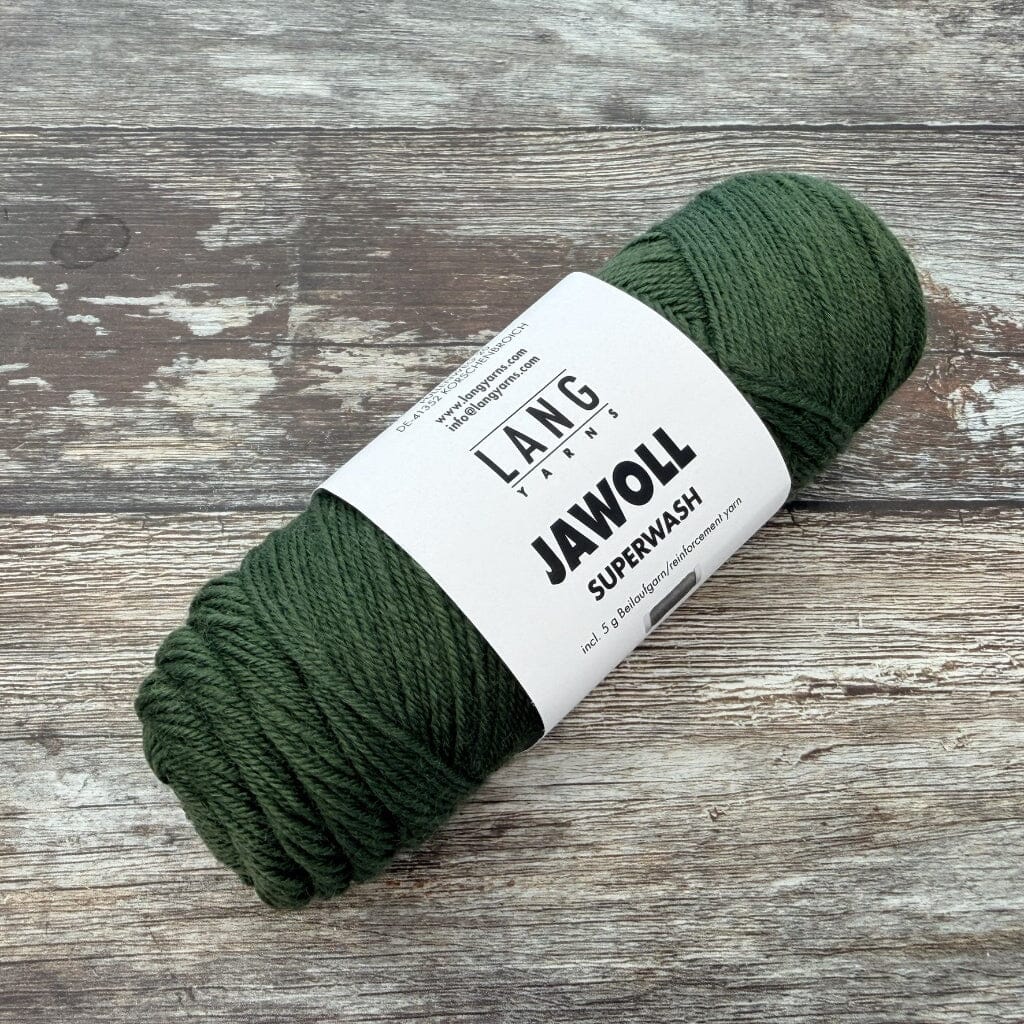 Forest Green ball of yarn with a label on a wooden surface