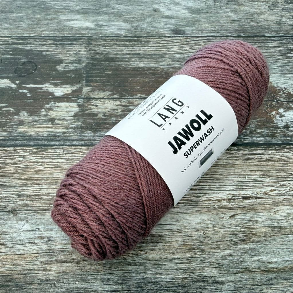 dusty rose Ball of yarn with a label on a wooden surface