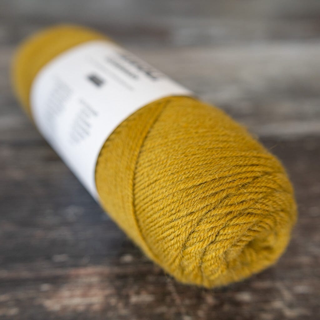 Yellow yarn ball on a wooden surface