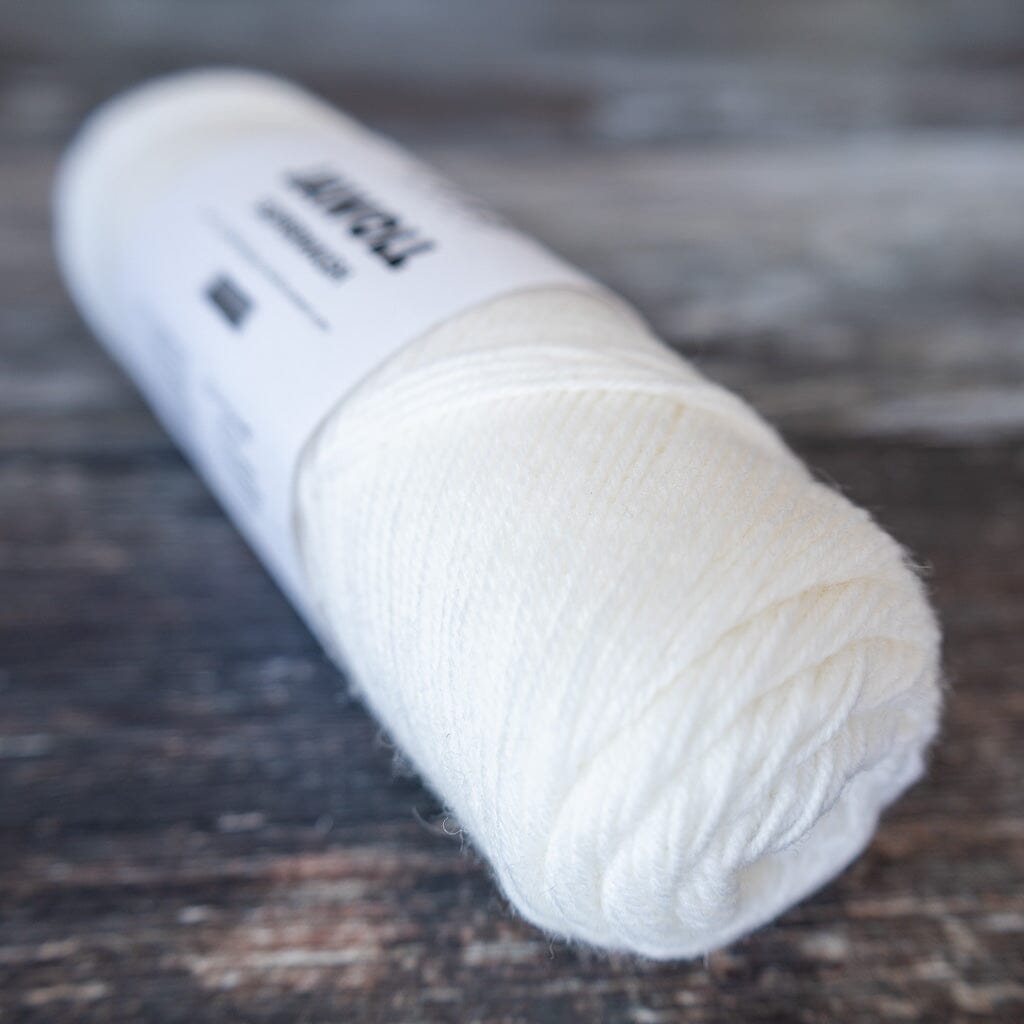 White yarn ball on a wooden surface