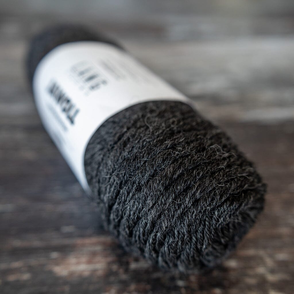 Grey sock yarn  with a white label on a wooden surface