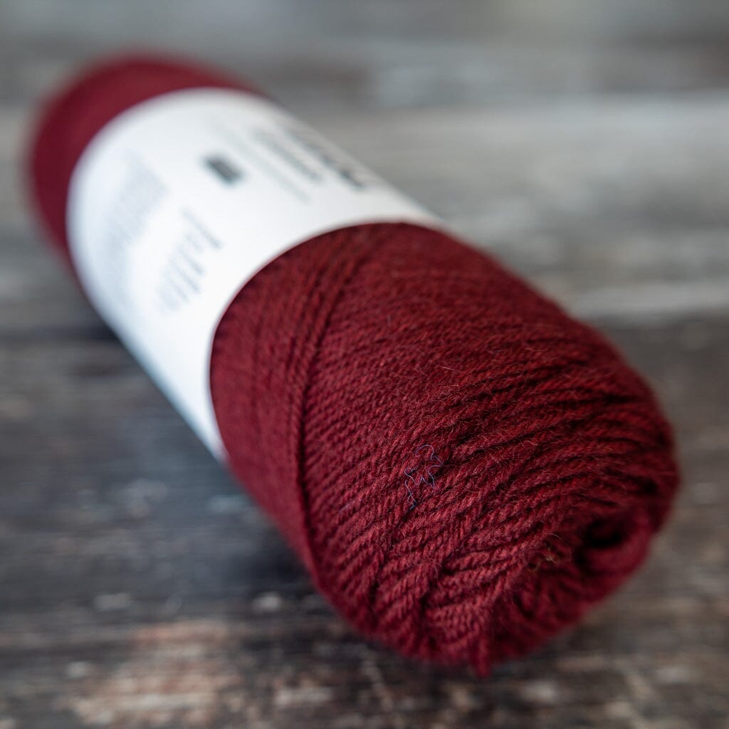 Red skein of yarn on a wooden surface