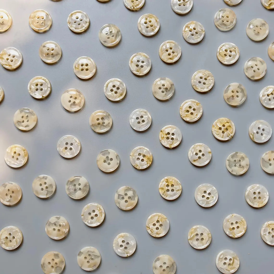 Pattern of beige buttons on a gray background