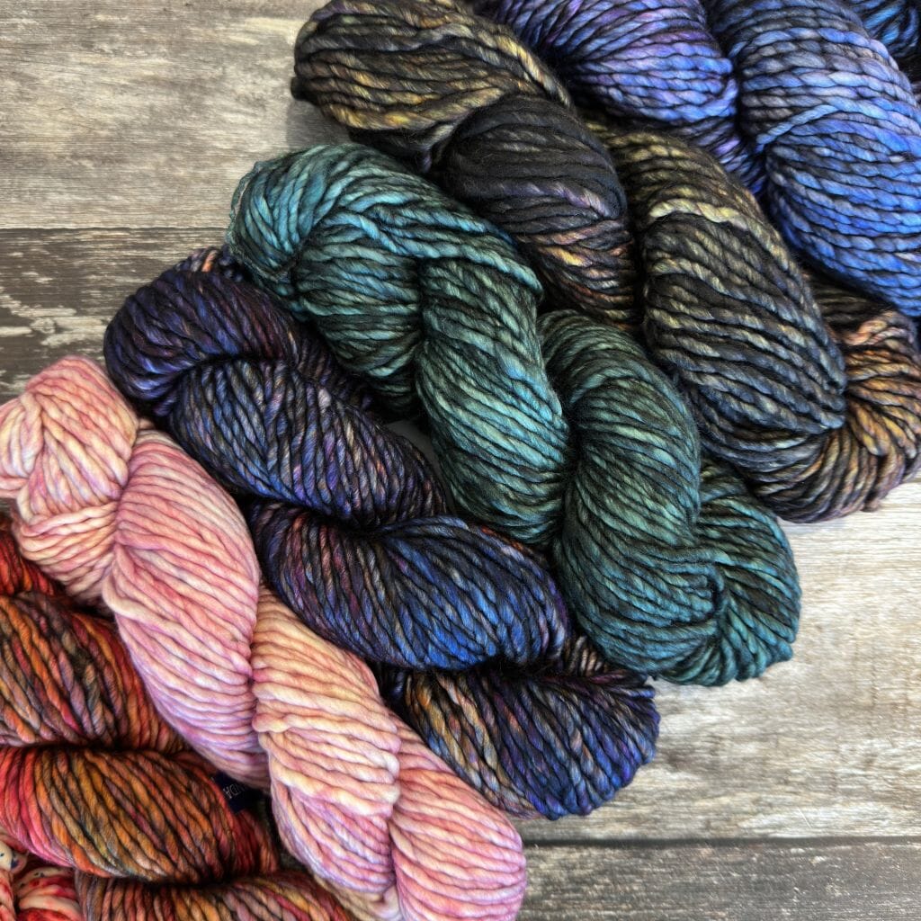 Colourful skeins of yarn on a wooden surface