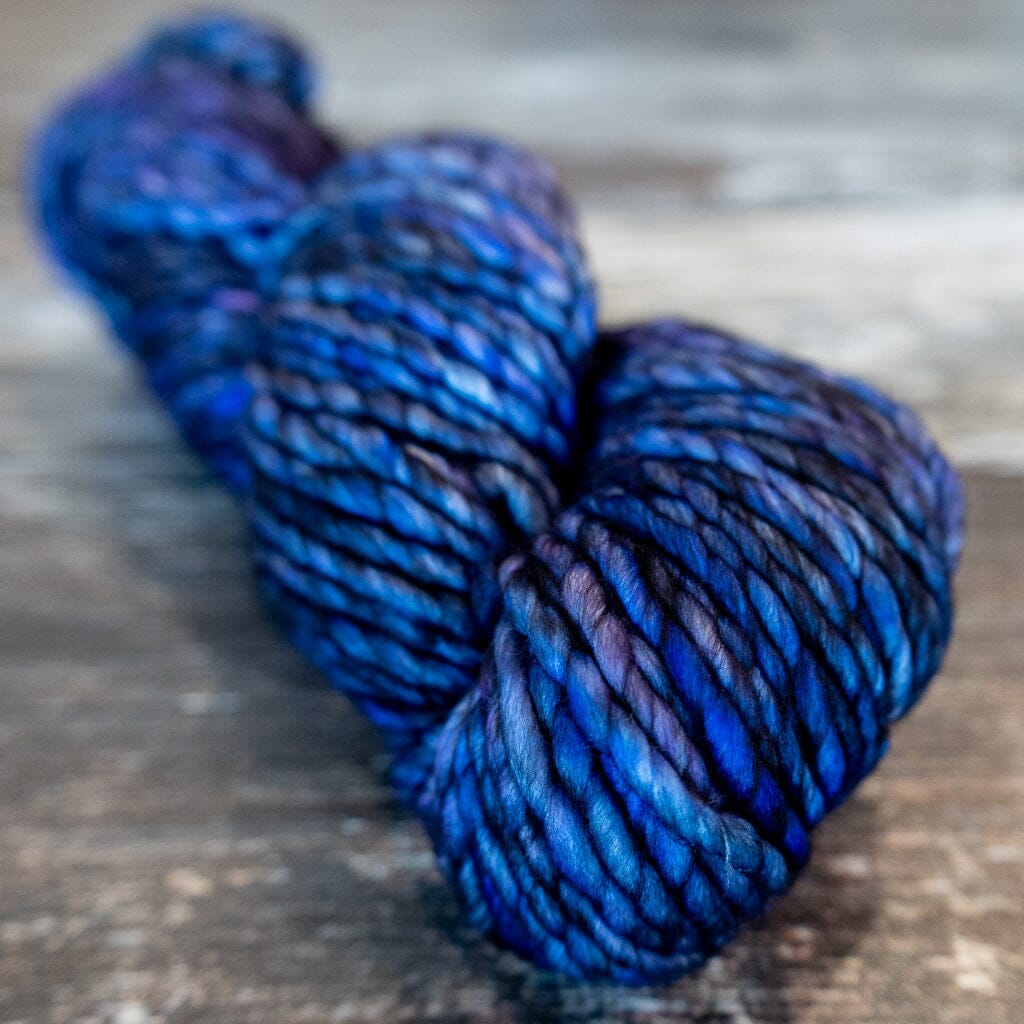 A skein of blue yarn on a wooden surface