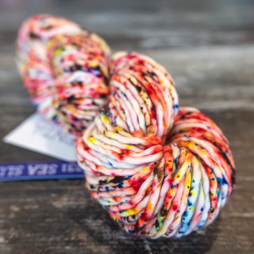 Multicoloured skein of yarn on a wooden surface