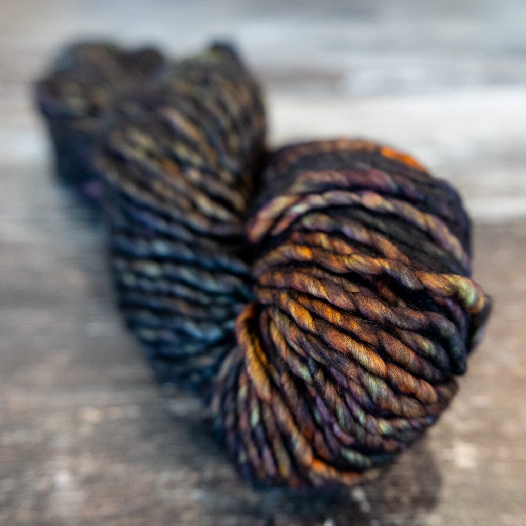 Multicoloured skein of yarn in browns and black on a textured surface