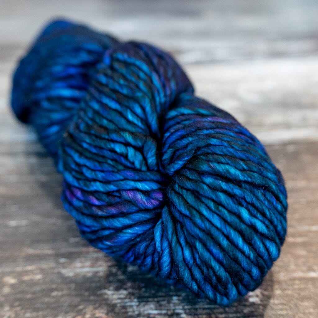 Blue and purple skein of yarn on a wooden surface