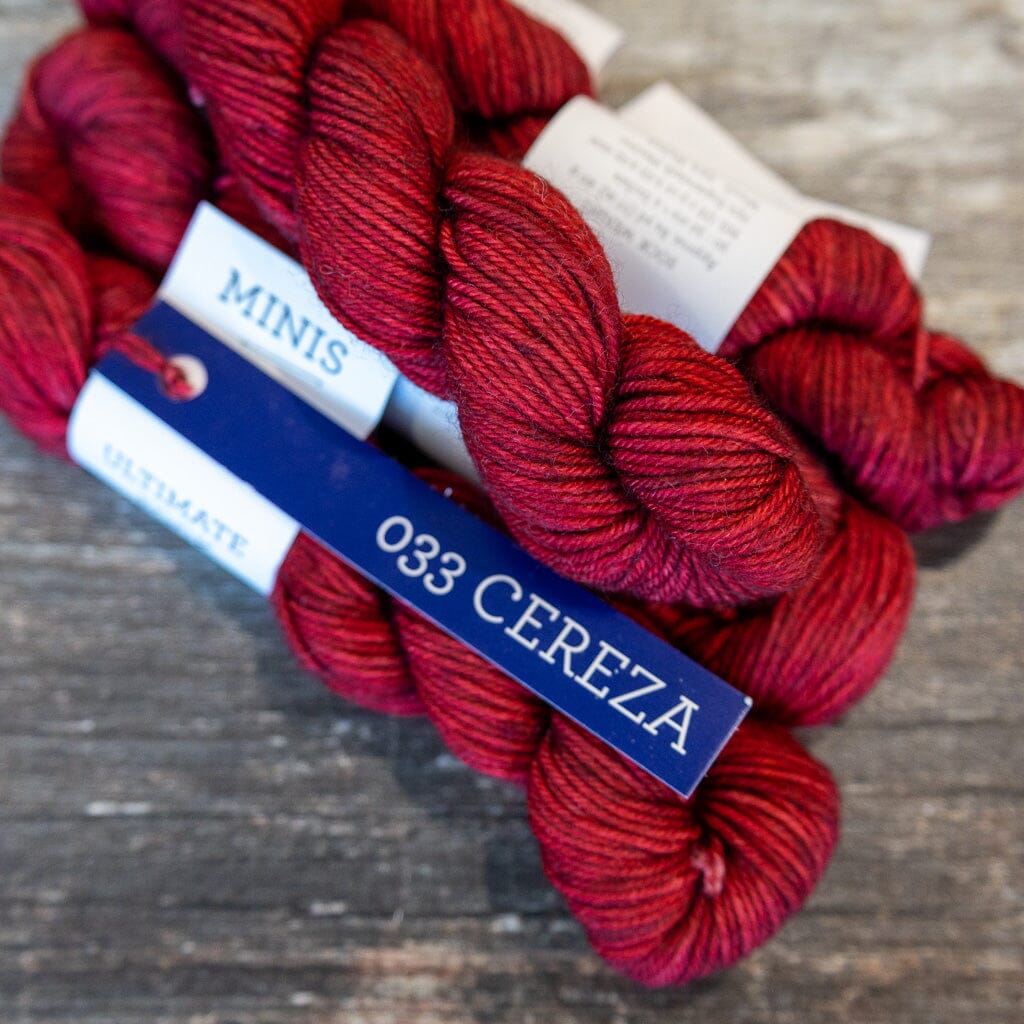 Balls of yarn labeled '142 Caramel' on a wooden surface