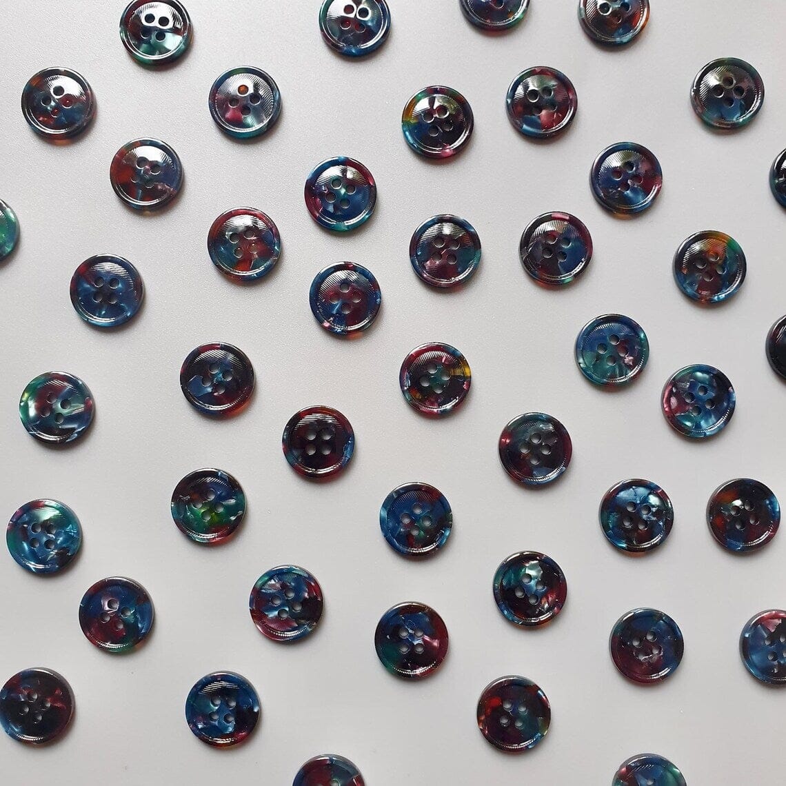 Pattern of colourful buttons on a white background