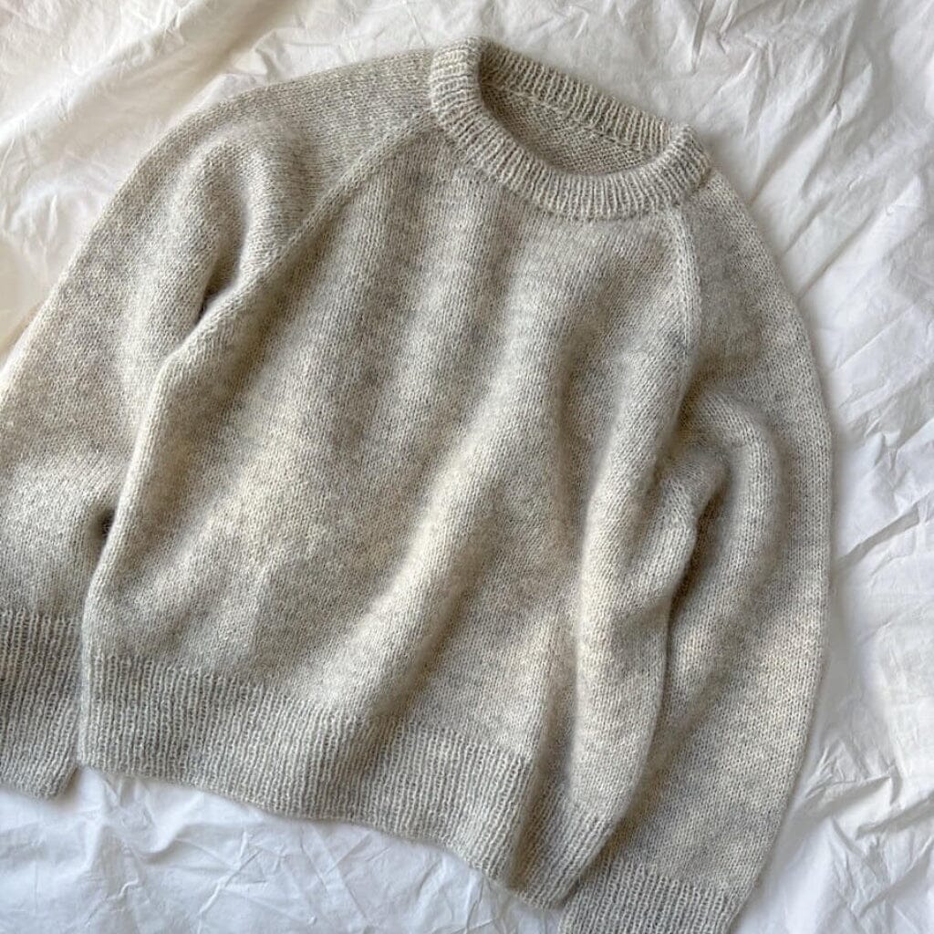 Beige sweater on a white textured surface