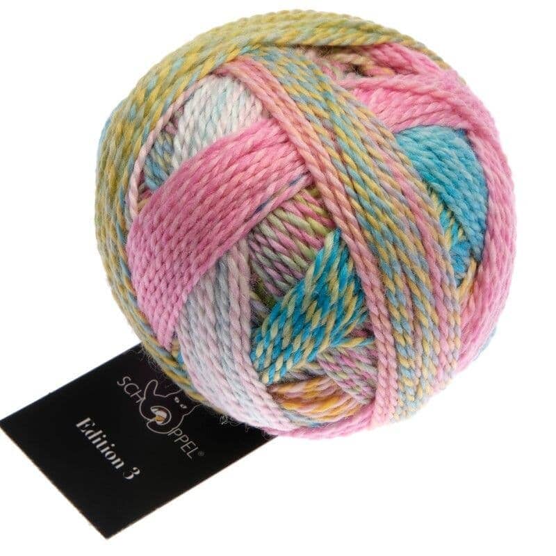 Multicolored skein of yarn with a Schachenmayr tag on a white background