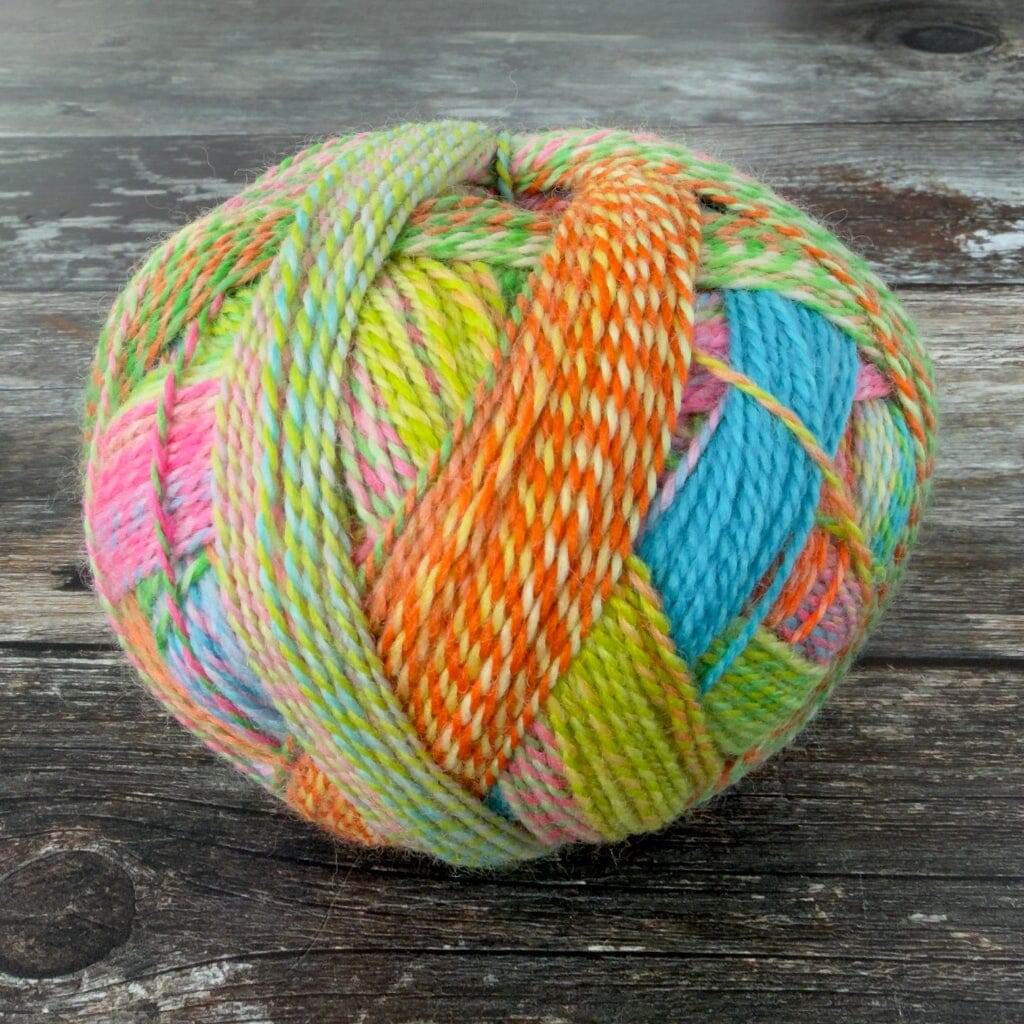 Multicolored skein of yarn on a wooden surface