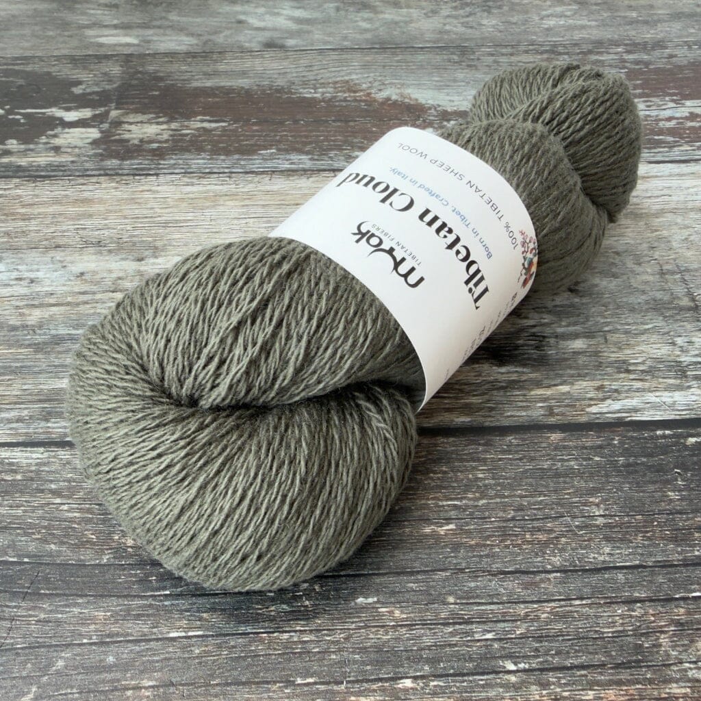 Ball of green yarn with a label on a wooden surface