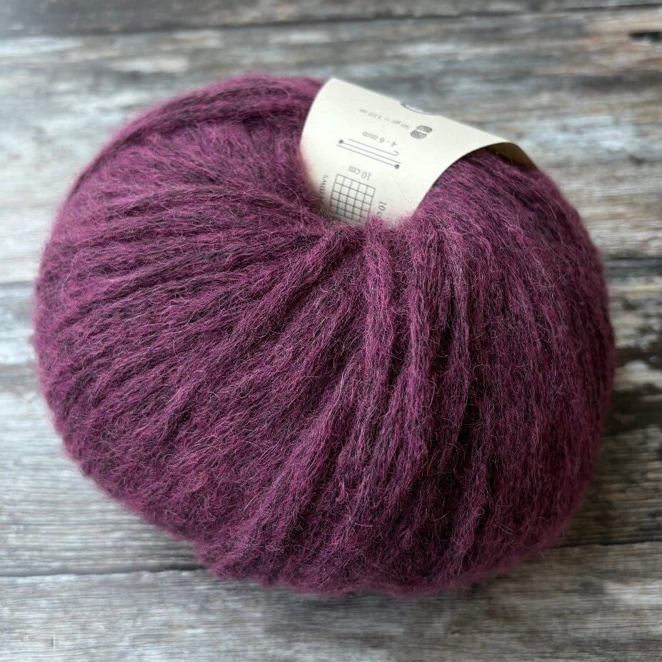 purple ball of knitting yarn on wooden surface