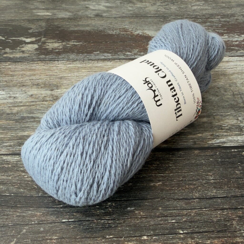 Pale blue skein of yarn with a label on a wooden surface