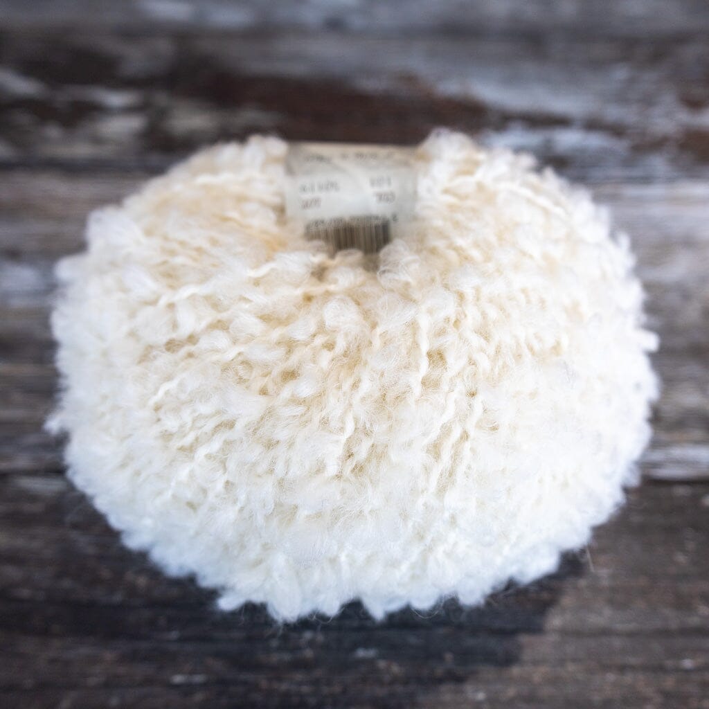 white boucle yarn on wooden surface