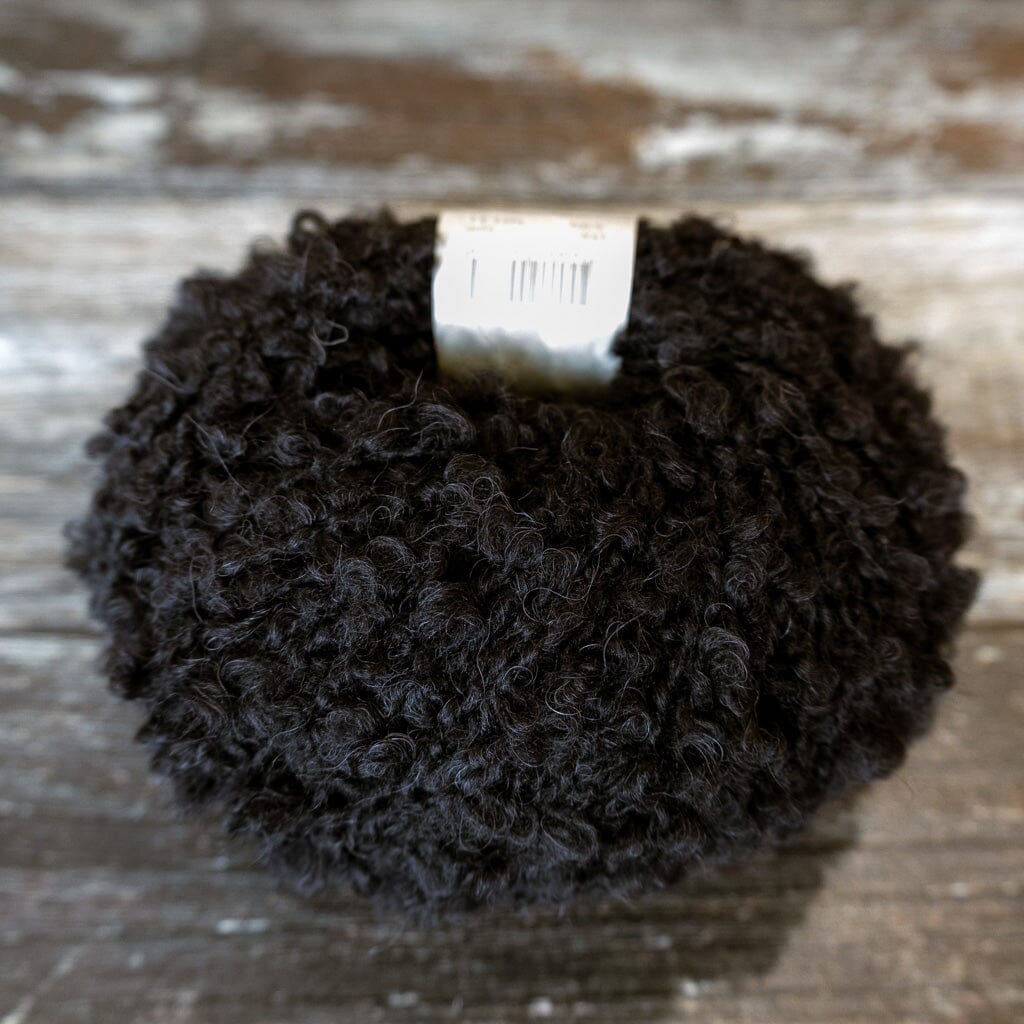black boucle yarn on wooden surface