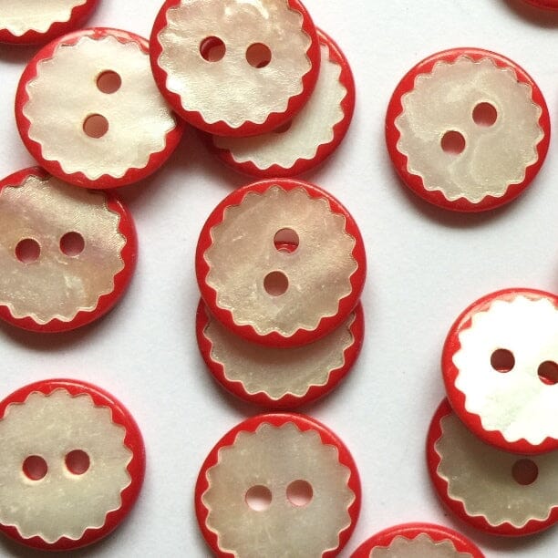 Red and white buttons with scalloped edges on a white background
