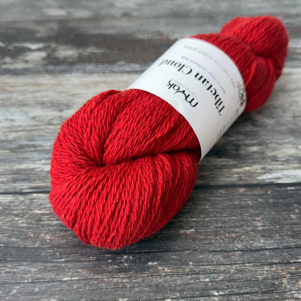 Red skein of yarn with a label on a wooden surface