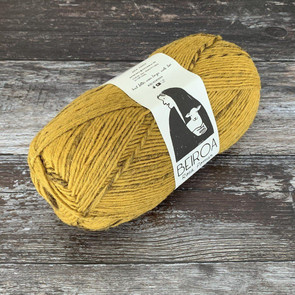 mustard ball of yarn on wooden surface with label beiroa